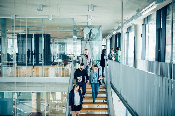 Studierende gehen die Treppe hinunter im Foyer der Bibliothek