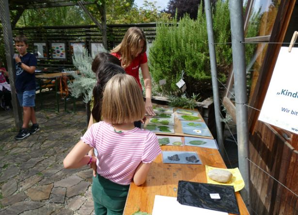 Kinder schauen Zeichnungen auf Holztisch an