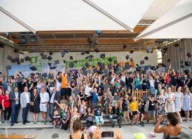 riesiges Kinder-Gruppenbild. Kinder werfen Hüte in die Luft